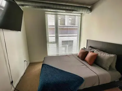 a bedroom with a bed with pillows and a window at 4 Brand new combined apartments with city views in Cleveland