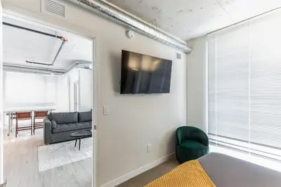 a living room with a couch and a television on a wall at 4 Brand new combined apartments with city views in Cleveland