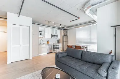 a living room with a couch and a table at 7 Brand new combined apartments with city views in Cleveland