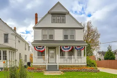 a white house with american flags on it at Walk to Beach Home with Pool in Vermilion in Vermilion