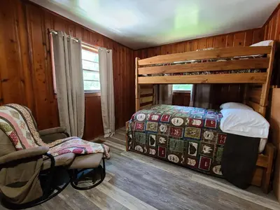 a bedroom with a bunk bed and a chair at The White Stag in Hillsboro
