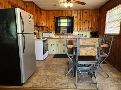 a kitchen with a refrigerator and a table and chairs at The White Stag in Hillsboro