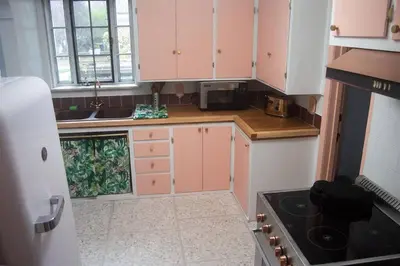 a small kitchen with pink cabinets and a stove at Tropical Deco in Toledo in Toledo