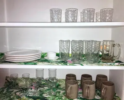 a shelf filled with glasses and plates and dishes at Tropical Deco in Toledo in Toledo