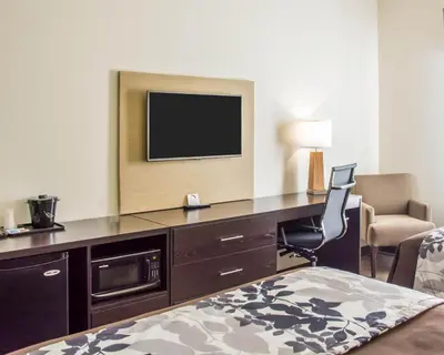 a hotel room with a desk with a television on it at Sleep Inn & Suites Parkersburg - Mineral Wells in Parkersburg