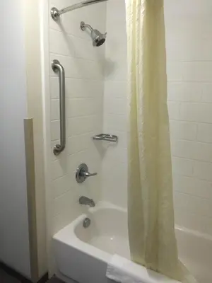 a bathroom with a tub and a shower with a shower curtain at Sleep Inn & Suites Parkersburg - Mineral Wells in Parkersburg
