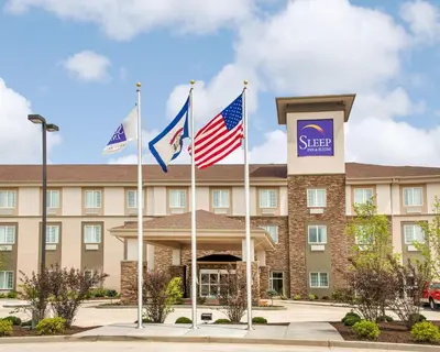 a hotel with flags in front of it at Sleep Inn & Suites Parkersburg - Mineral Wells in Parkersburg