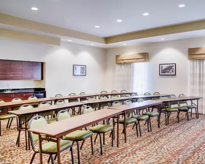 a classroom with tables and chairs and a podium at Sleep Inn & Suites Parkersburg - Mineral Wells in Parkersburg
