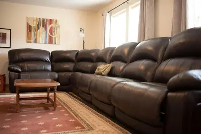 a brown leather couch in a living room with a table at Adventure Hub Biking Hiking Hunting Paddle in Athens