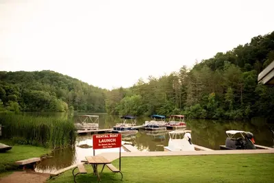 a sign in front of a lake with boats in it at Tiny House Strouds Run Lake in Athens
