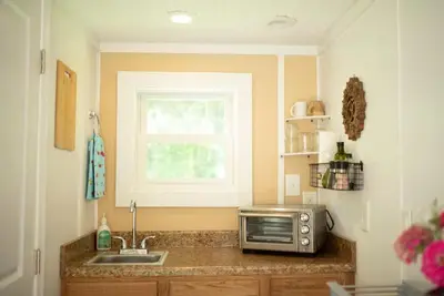 a kitchen with a sink and a microwave on a counter at Tiny House Strouds Run Lake in Athens