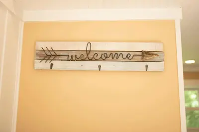 a sign that says welcome hanging on a wall at Tiny House Strouds Run Lake in Athens