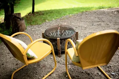 two chairs and a coffee table in a yard at Tiny House Strouds Run Lake in Athens