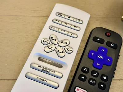a remote control with buttons on it next to a remote control at Parma Ranch with Hot Tub and Game and Media Room in Parma