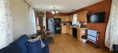 a living room with a blue couch and a kitchen at The Lake House in Hillsboro