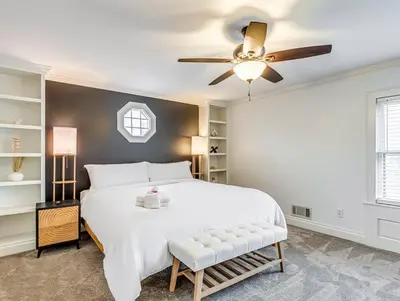 a bedroom with a white bed and a ceiling fan at Upscale Historic Home near Downtown, Hall of Fame, Beach, Arenas in Cleveland