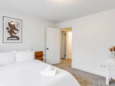 a white bedroom with a white bed and a door at Upscale Historic Home near Downtown, Hall of Fame, Beach, Arenas in Cleveland