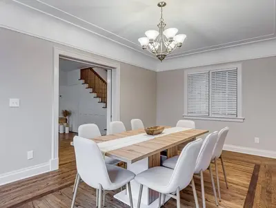 a dining room with a wooden table and white chairs at Upscale Historic Home near Downtown, Hall of Fame, Beach, Arenas in Cleveland