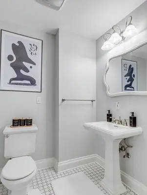 a white bathroom with a toilet and a sink at Upscale Historic Home near Downtown, Hall of Fame, Beach, Arenas in Cleveland