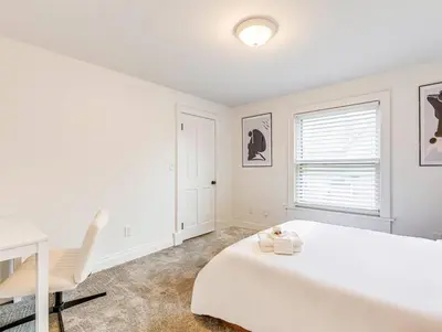a white bedroom with a white bed and a desk at Upscale Historic Home near Downtown, Hall of Fame, Beach, Arenas in Cleveland