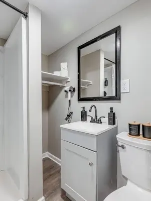 a white bathroom with a sink and a mirror at Upscale Home near Downtown Cle, R&R HoF, Beach, Arena in Cleveland
