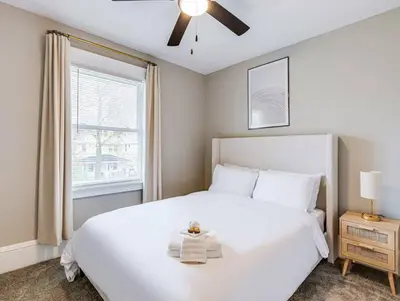 a bedroom with a white bed and a window at Upscale Home near Downtown Cle, R&R HoF, Beach, Arena in Cleveland