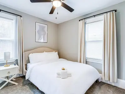 a bedroom with a white bed and a ceiling fan at Upscale Home near Downtown Cle, R&R HoF, Beach, Arena in Cleveland