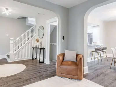 a living room with a chair and a staircase at Upscale Home near Downtown Cle, R&R HoF, Beach, Arena in Cleveland