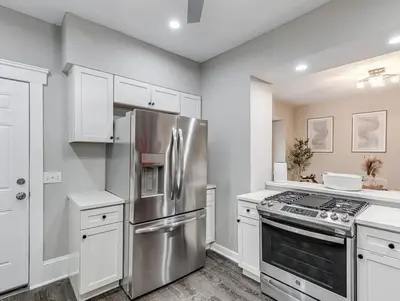 a kitchen with a stainless steel refrigerator and white cabinets at Upscale Home near Downtown Cle, R&R HoF, Beach, Arena in Cleveland