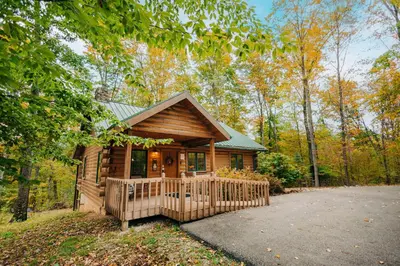 a wooden cabin in the woods with a fence at Ferngully Creek Cabins in Millersburg