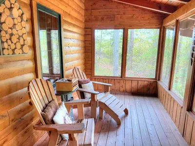 a dining room with a table and chairs in a log cabin at Ferngully Creek Cabins in Millersburg