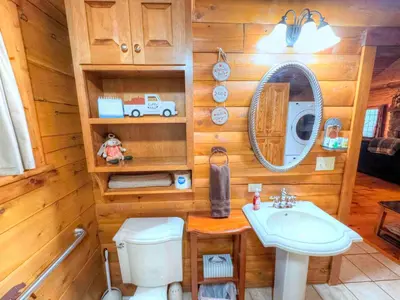 a bathroom with a sink and a toilet and a mirror at Ferngully Creek Cabins in Millersburg