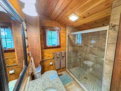 a bathroom with a shower and a toilet at Ferngully Creek Cabins in Millersburg