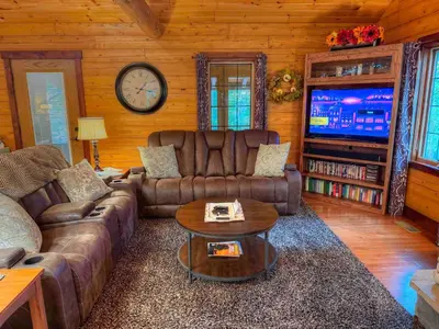a living room with a couch and a tv at Ferngully Creek Cabins in Millersburg