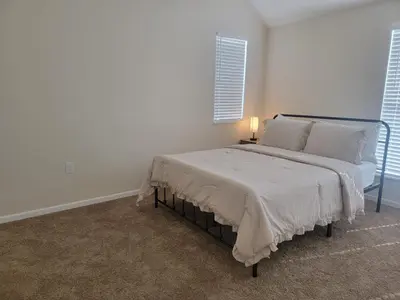 a white bedroom with a bed with a lamp on it at Charming 4BR New Home Columbus With Garage Parking in Columbus