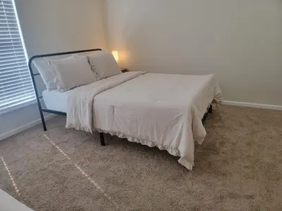a bed with white sheets and pillows in a room at Charming 4BR New Home Columbus With Garage Parking in Columbus