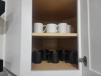 a cupboard with a bunch of coffee mugs at Charming 4BR New Home Columbus With Garage Parking in Columbus