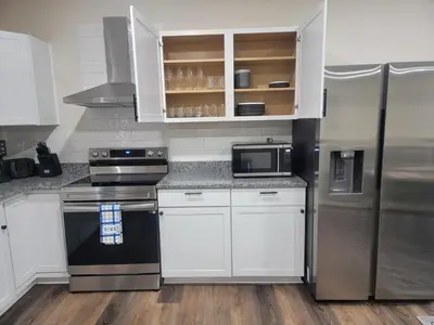 a kitchen with white cabinets and a stainless steel refrigerator at Charming 4BR New Home Columbus With Garage Parking in Columbus