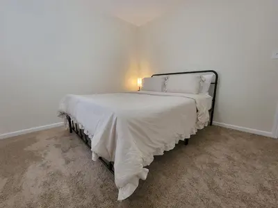 a bedroom with a bed with a white comforter at Charming 4BR New Home Columbus With Garage Parking in Columbus