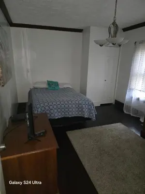 a bedroom with a bed and a dresser with a tv at Leisure guest home in Lorain