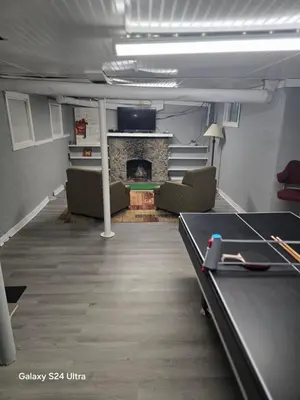 a room with a ping pong table and a fireplace at Leisure guest home in Lorain