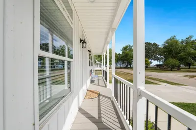 a front porch of a white house with windows at Lake Erie Serenity Hutch in Port Clinton