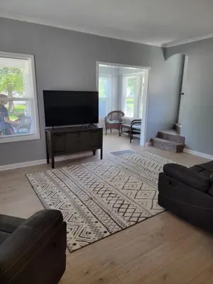 a living room with a flat screen tv and a couch at Lake Erie Beach Hutch in Port Clinton