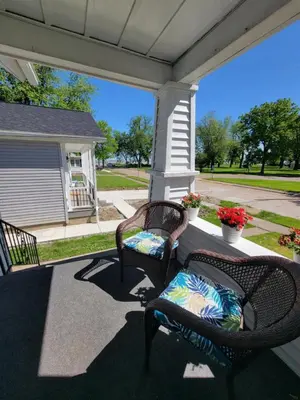 two wicker chairs sitting on a front porch at Lake Erie Beach Hutch in Port Clinton