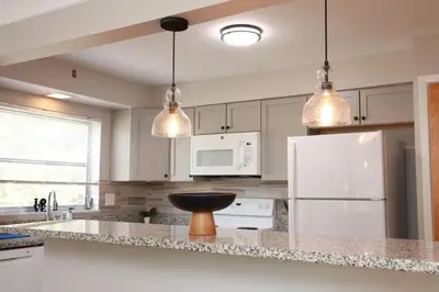a kitchen with white appliances and two pendant lights at 30day Conveniently Located in a Quiet Suburb in Cincinnati