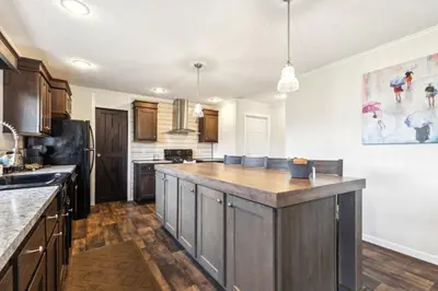 a kitchen with wooden cabinets and a large island at Sunsets & Serenity- Port Clinton Waterfront Stay home in Port Clinton
