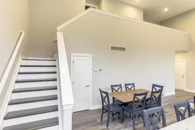 a dining room with a table and chairs and a staircase at 24 Mi to Cincinnati Newly Built Bethel Home! in Batavia