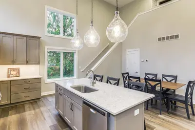 a kitchen with a sink and a table with chairs at 24 Mi to Cincinnati Newly Built Bethel Home! in Batavia