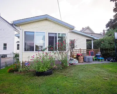 a house with a yard with some plants and flowers at Rosewood Ranch in Lakewood