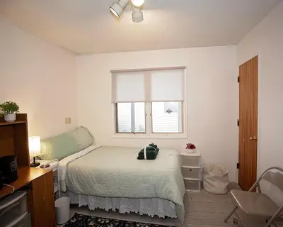 a white bedroom with a bed and a window at Rosewood Ranch in Lakewood